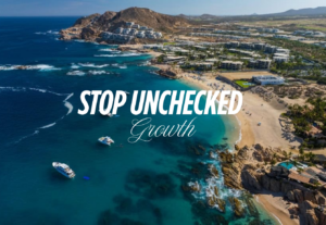 Low-rise terracotta luxury resorts along the Los Cabos coastline with desert mountains and Sea of Cortez representing the natural landscape that Los Cabos sustainable development must protect from unchecked vertical growth